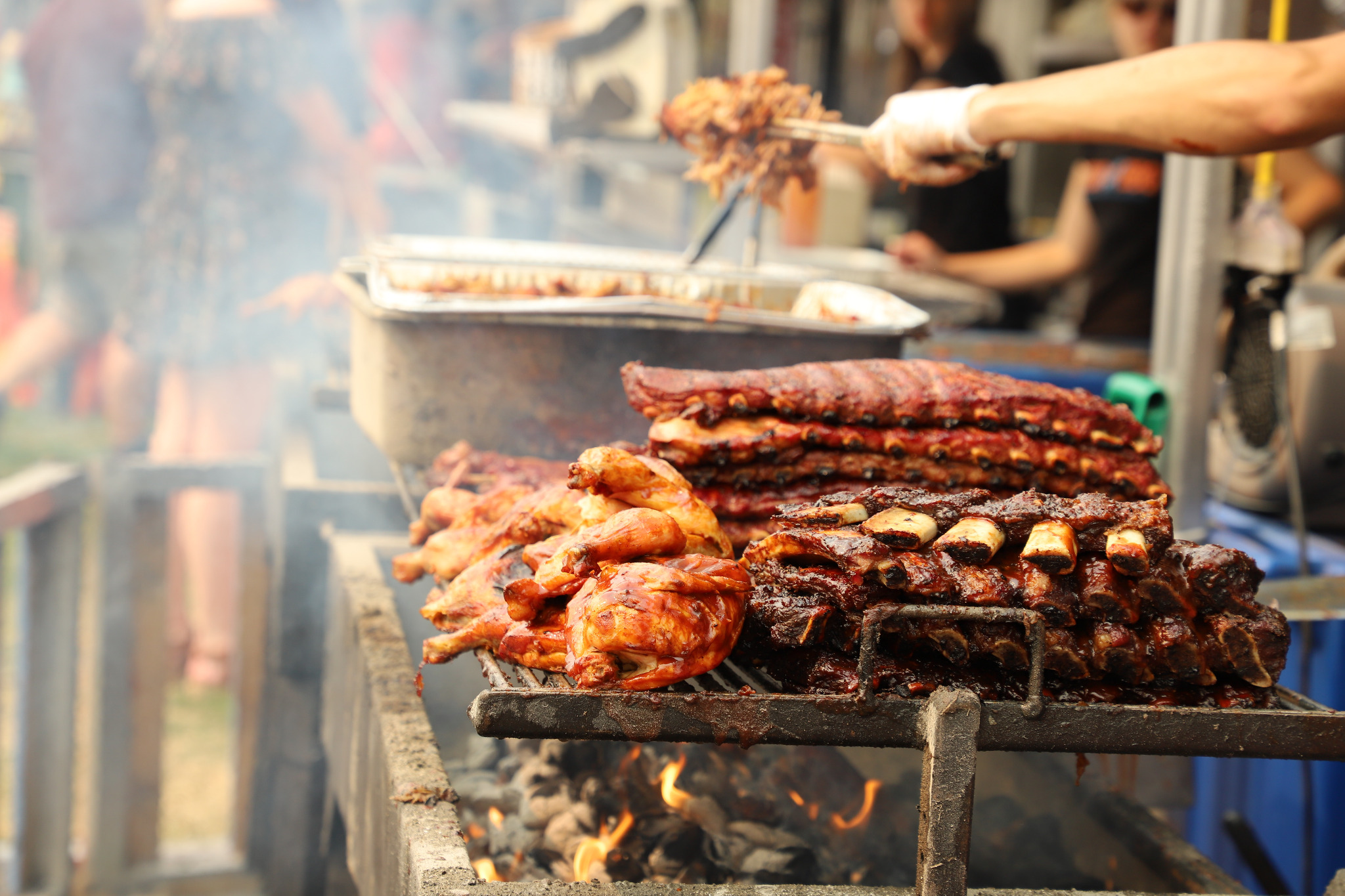 Barbecue chicken and ribs cooking on an open grill