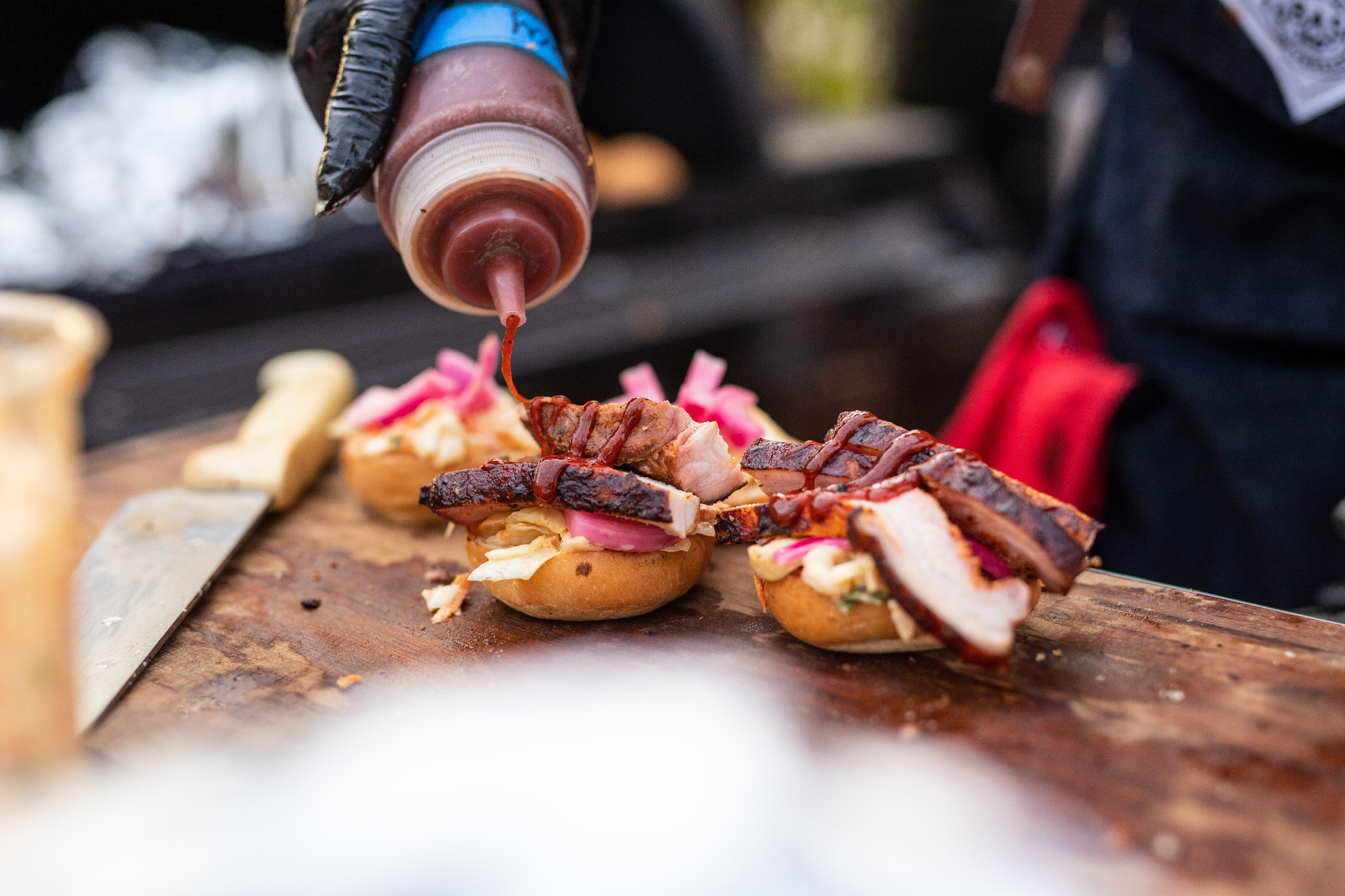 Barbecue sandwich being finished with tangy barbecue sauce